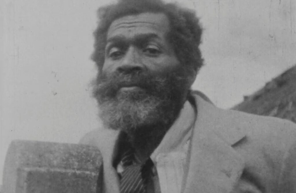Amos Brown sporting a bushy beard and wearing a tied and jacket.