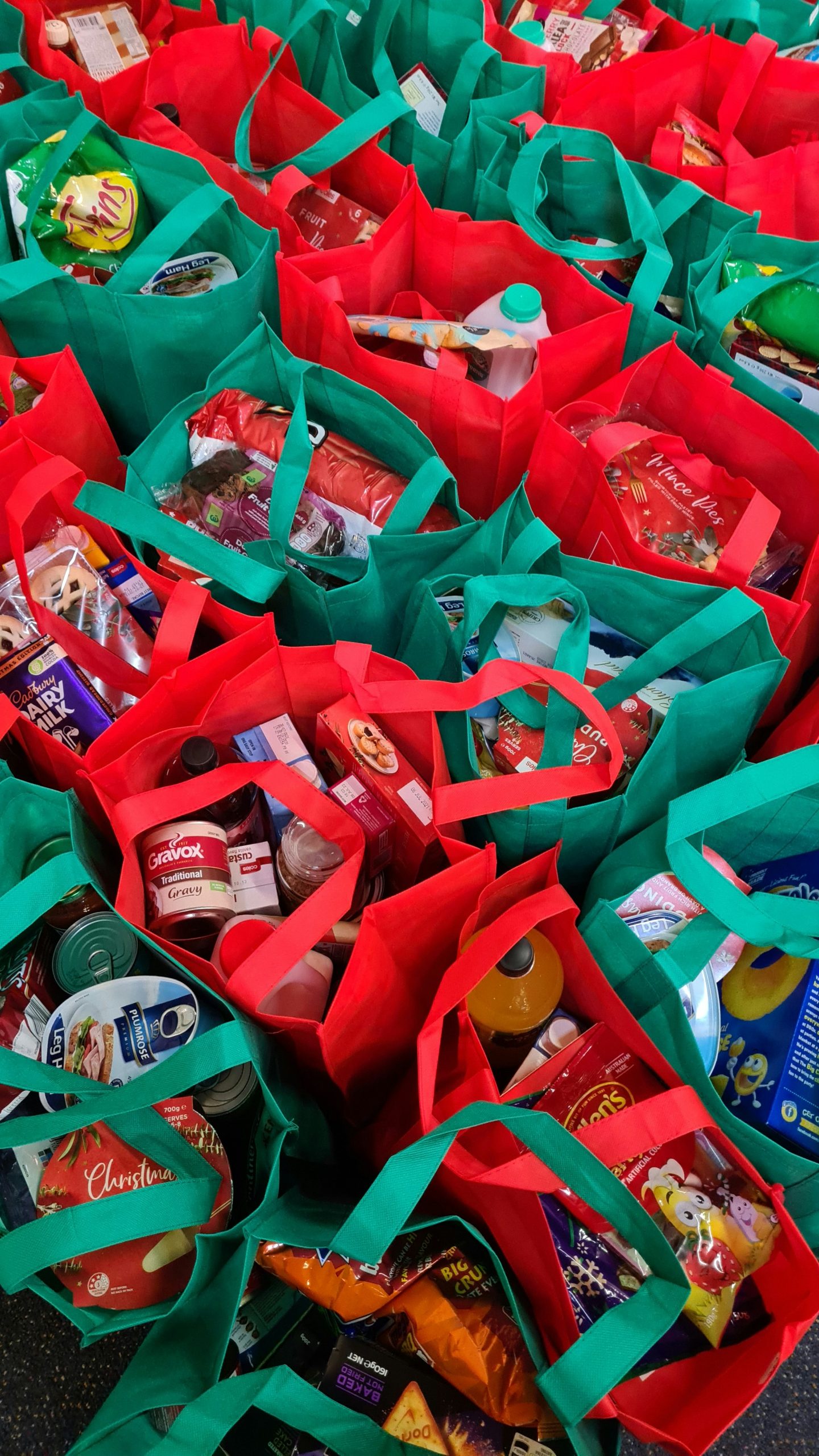Reusable tote bags full of canned and packaged holiday foods.
